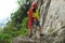 Rock climber standing with climbing gears and rope