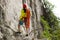 Rock climber standing in front of mountain cliff outdoor