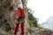 Rock climber standing in front of mountain cliff outdoor