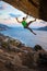 Rock climber waving his hand while climbing