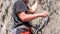 Rock climbing. Climber close-up. Extreme sport. A young climber climbs a vertical granite rock.