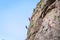 Rock climbing. A group of young rock climbers climb the vertical granite rock. Extreme sport.