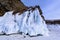 Rock covered with icicles. Lake Baikal in cloudy weather.