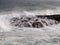 Rock covered by the waves of the sea where ships can wrecked