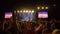 Rock festival, many of fans clap hands and enjoy music at concert in brightly lit scenes in slow motion