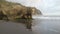 Rock formation arrangement with one single rock looks like a sitting dog animal looking to the sea with reflections and shadows