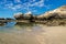 Rock formation with cliff and beach with reflections in the sea at Peterborough beach, Victoria, Australia