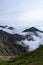 Rock formations in grassy mountains above the clouds at Mount Kisokoma