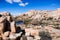 Rock formations surrounding Barker Dam, tourists relaxing on the shoreline; Joshua Tree National Park, California