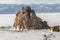 Rock on the ice of winter Baikal on Olkhon island in Siberia. Beautiful nature: mountains, frozen lake, blue sky