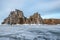 Rock on the ice of winter Baikal on Olkhon island in Siberia. Beautiful nature: mountains, frozen lake, sky