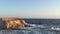 Rock islet in choppy sea in the early morning