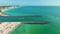 Rock jetty barrier and boats sailing at harbor on colorful ocean water near Venice and Nokomis beach in Sarasota County