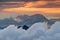 Rock massif of Kamnik Savinja Alps rise above clouds at sunrise