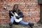 A rock musician girl in a leather jacket with a guitar