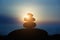 Rock pebble pyramid silhouette at sunset light, zen stones on sea beach