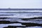 Rock Pools On Sea Shore With Ocean Horizon And Oil Drilling Platform In The Distance