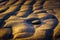 Rock on sand formations at the beach at sunset