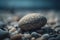 a rock sitting on top of a pile of rocks on top of a beach