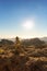 Rock stacking and view from Roque Nublo with sun in the background