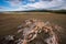 Rock in the steppe near to the road going to the forest.