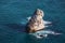 Rock stone above sea surface, water with foam splashes, beautiful Crimean summer ocean background