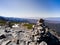 Rock, stone and cairn on hill with the clear blue sky and mountains background