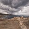 Rock striations near Ile Rousse in Corsica and stormy clouds