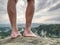 Rock with tired hikers legs without shoes. Naked male legs.