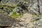 Rock wall in the mountains with fallen pieces of rock in front