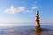 Rock zen pyramid of colorful pebbles standing in the water on the background of the sea