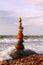 Rock zen pyramid of colorful pebbles standing in the water on the background of the sea