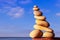 Rock zen pyramid of yellow stones on a beach on the background of the sea. Concept of Life balance