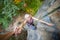 Rockclimber helping to female climber to reach top of mountain