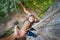 Rockclimber helping to female climber to reach top of mountain