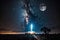 rocket launch in the dead of night, with starry sky and silhouetted moon visible