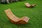 Rocking chair on the lawn. wet wooden deck chairs for one person in the garden or park. They are comfortable made of brown planks,