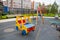 Rocking chair on a yellow and blue metal spring made of natural wood in the shape of a car on a playground