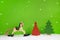 Rocking horse and red christmas tree on green background.