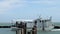 ROCKPORT, TX - 3 FEB 2020: A white oyster boat sails into the Fulton Harbor, past the wooden posts of a pier, with the days