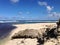 Rocks and beach with calm ocean and blue sky