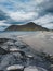 Rocks on beach of fjord of Norwegian sea in winter with snow. Skagsanden beach, with blue sky and clouds in Lofoten