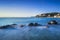 Rocks in a blue ocean on sunset. Castiglioncello, Tuscany Italy