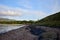 Rocks blurry background sand small water ocean clouds person