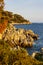 Rocks and cliffs shoreline of Cap Ferrat cape hosting Saint-Jean-Cap-Ferrat resort town on at French Riviera in France