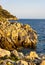 Rocks and cliffs shoreline of Cap Ferrat cape hosting Saint-Jean-Cap-Ferrat resort town on at French Riviera in France