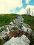 Rocks climbing a hill jagged and sticking out all different colors brown gray green blue