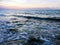 Rocks covered with algae on eroded beach at sunset