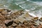 Rocks leading out to waves in emerald ocean water