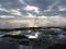 Rocks lunar landscape sea with giants cumulonimbus clouds in the sky and cargo ships at the horizon . Tuscany, Italy